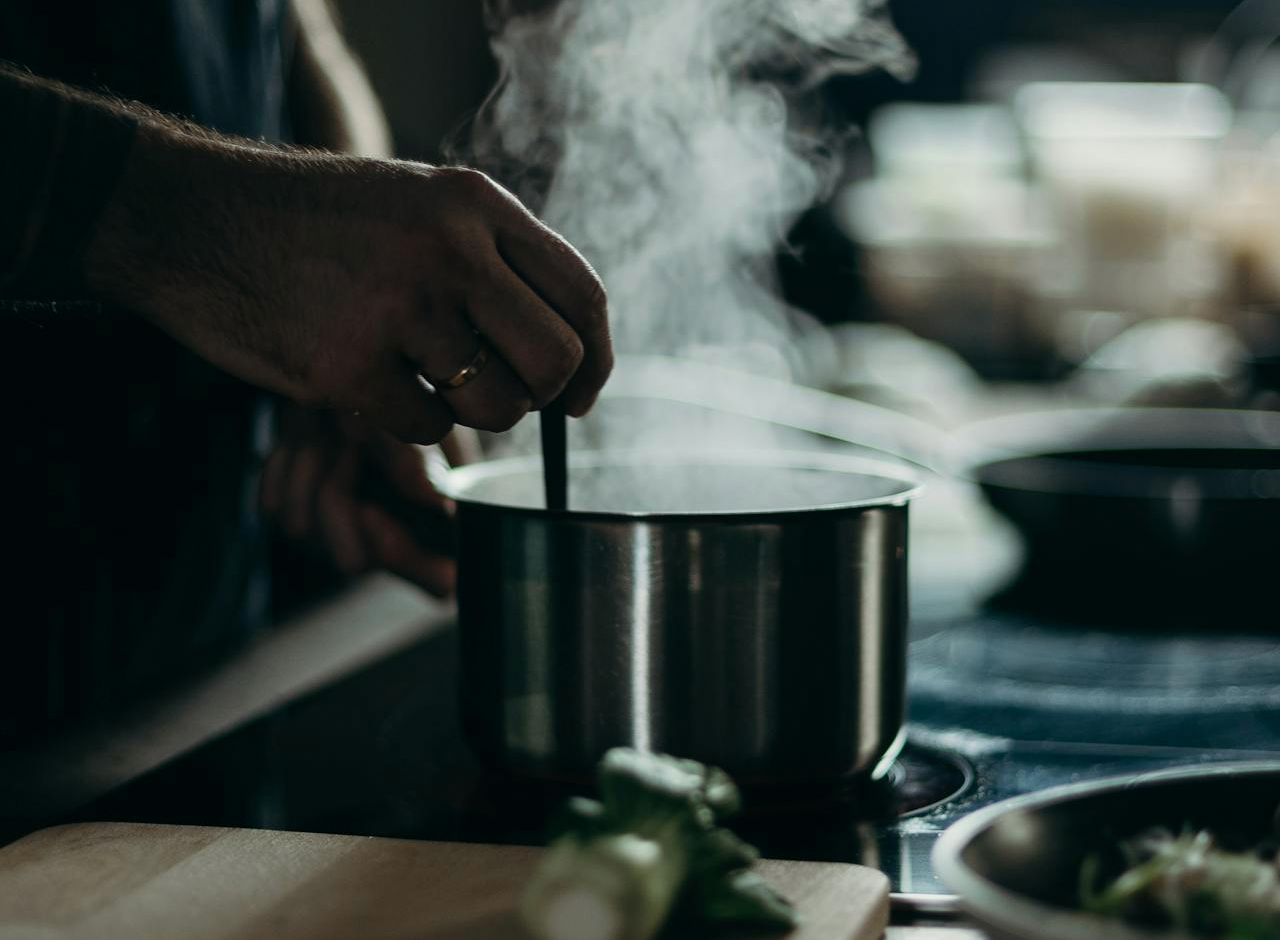 Une personne remue le contenu d'une casserole.